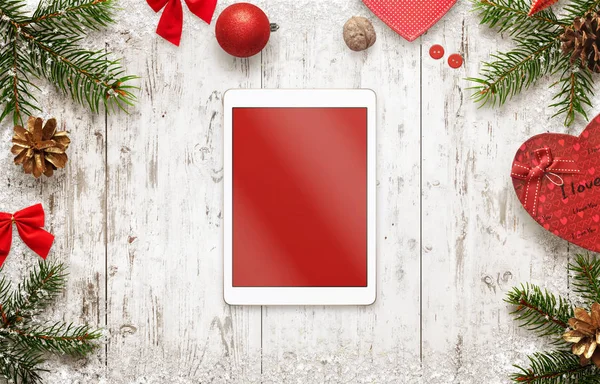 Tablet with isolated screen for mockup with christmas decorations on table. Top view of white wooden desk with christmas tree and gifts