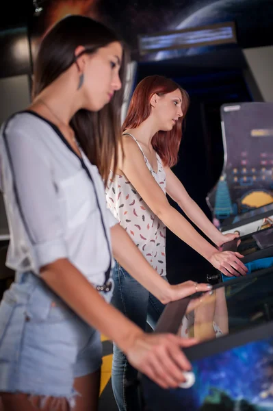 Young woman playing on the pinball machine