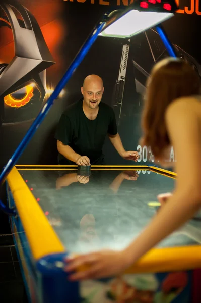 Young couple playing a game of air hockey