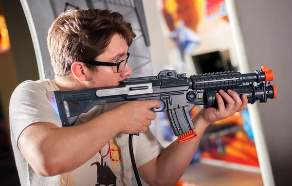 Young man playing with a toy shotgun