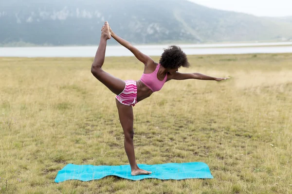 Emale athlete stretching outdoors in mountains