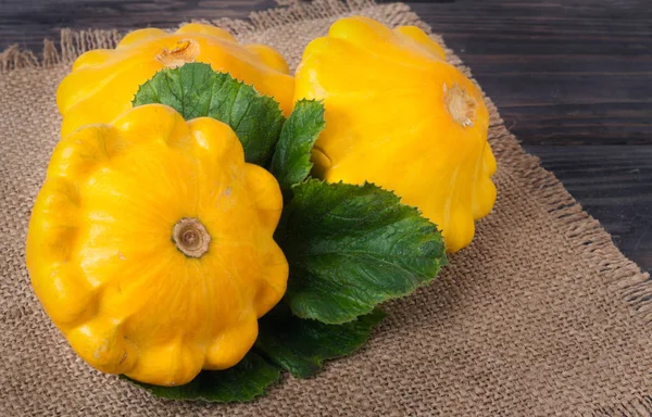 Yellow squash on a wooden background with napkin of burlap