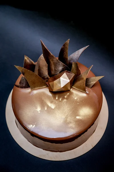 Trendy modern chocolate mousse cake decorated with mirror glaze and chocolate decor. Black background.