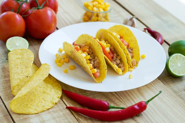 Baked taco shells with chicken mince, tomato and corn