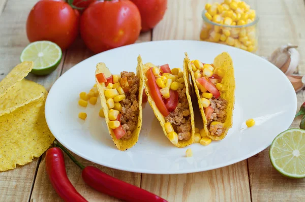 Three crispy tacos with chicken mince, tomatoes and corn