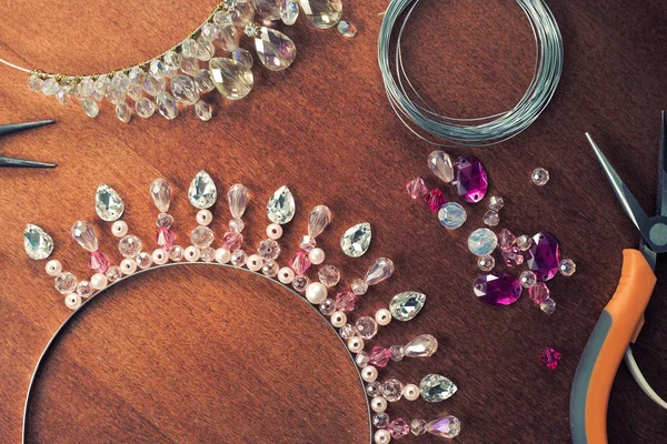 The process of creating jewelry from wire and crystals. Working tools on the table. Handmade jewelry. Homemade products. The crown for the bride in the manufacturing process.