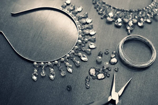 The process of creating jewelry from wire and crystals. Working tools on the table. Handmade jewelry. Homemade products. The crown for the bride in the manufacturing process.