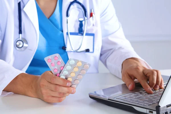 Male medicine doctor hands hold jar of pills and type something on laptop computer keyboard. Panacea life save, prescribing treatment, legal drug store, take stock, consumption statistics concept