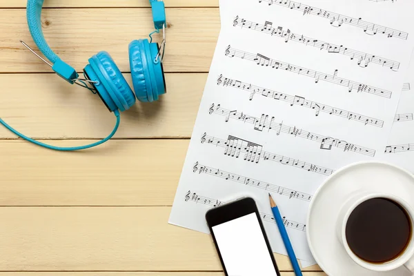 music sheet note paper,headphones,smartphone,pencil.