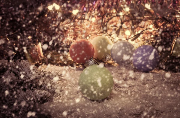 Vintage christmas bacground with multicolor christmas decorations on snow.