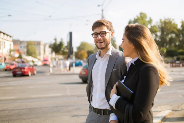 Happy business couple in street