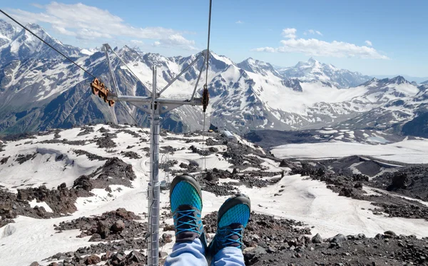 Legs in sneakers on a background of mountain landscape