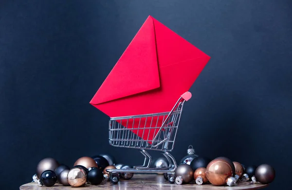 Red letter and cart with christmas baubles