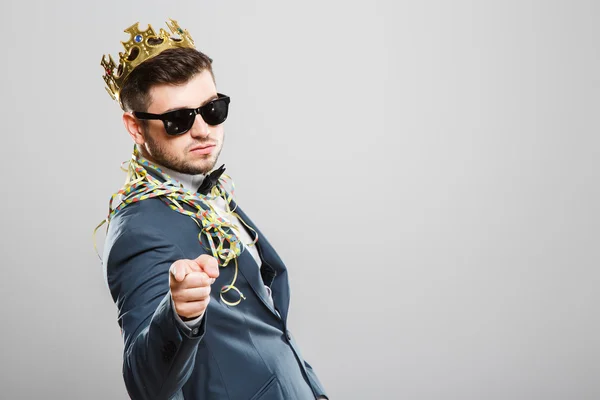 Man in crown pointing at camera