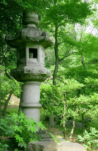 Japanese outdoor stone lantern and lake in zen garden