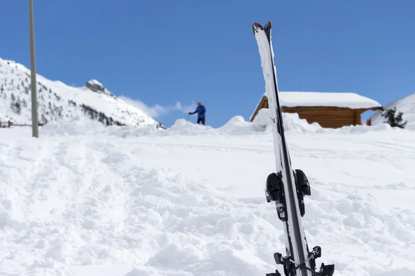 Close up of skis in the snow with background blue sky and the ski slope