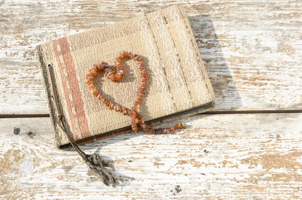 Old photo album with amber necklace heart