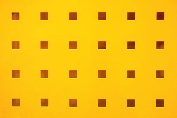 Yellow coated metal plate with the rectangular hole pattern
