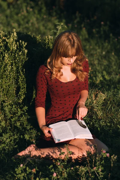 Beautiful woman reading book in nature