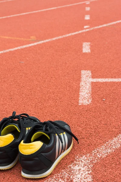 Sport shoes on running track background