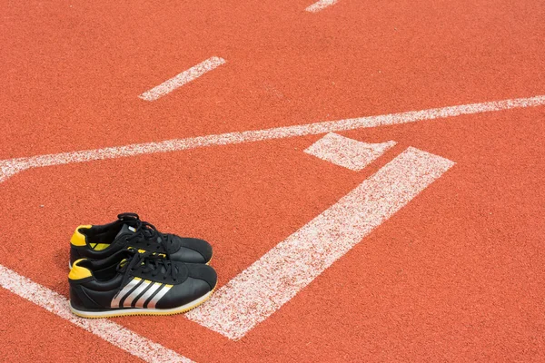 Sport shoes on running track background