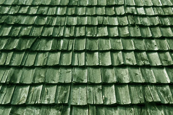 Weathered green wooden tile roof texture.