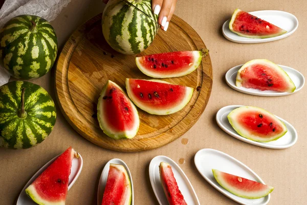 Slices of watermelon. Children's hands cooking fruit salad. Top view