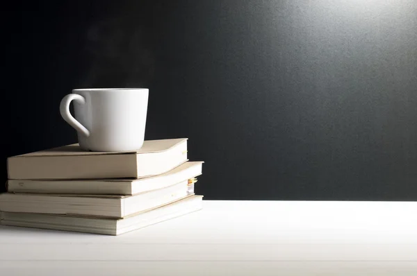 Still life - A cup of hot coffee on old books.