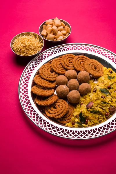 Plate full of indian festival food or diwali food or snacks like laddu, chivda, chakali or murukku, sev and shankar pale, sweet and salty snack food