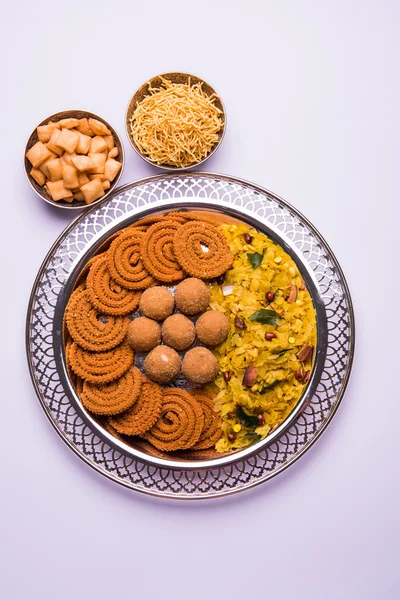 Plate full of indian festival food or diwali food or snacks like laddu, chivda, chakali or murukku, sev and shankar pale, sweet and salty snack food