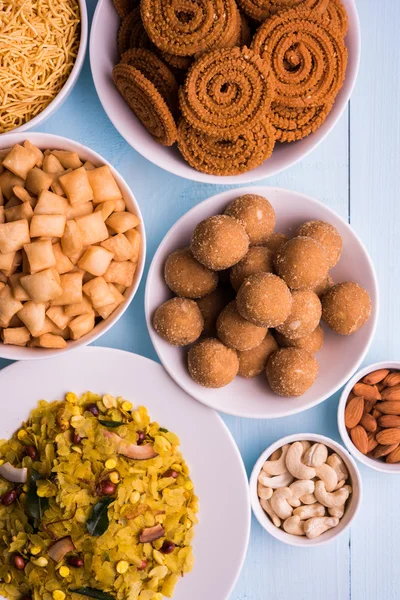 Home made tasty Diwali food or Diwali snacks or Diwali sweets like rava laddu, chakli, sev,shankar pale and chivda or chiwada with dry fruits in white bowls, favourite indian diwali recipe