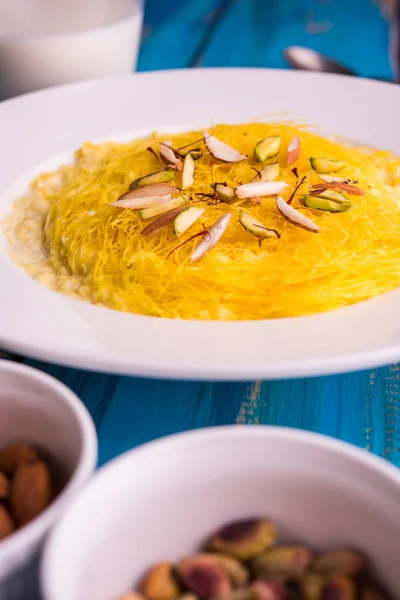 Indian sweet kesar sutarfeni or sutar feni or firni or seviyan or laccha, shredded, flaky-rice-flour roasted in ghee, blended with melted sugar to form a cotton candy, with pistachio and almonds