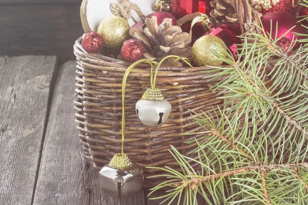 Christmas jewelry in a basket on a wooden background. Toning