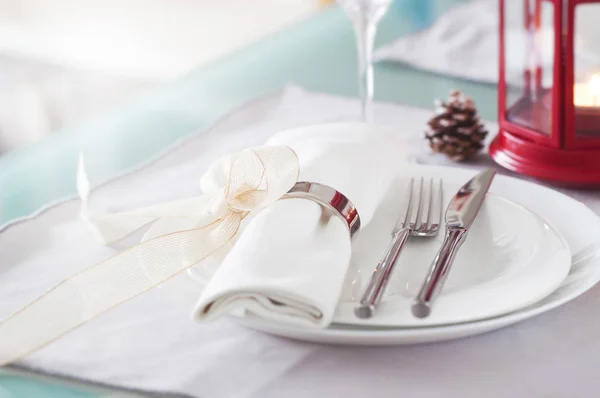 Elegant decorated Christmas table setting with modern cutlery, napkin, bow and christmas decorations. Christmas menu concept, closeup, horizontal
