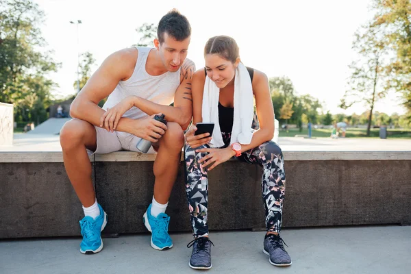 Man and woman in sportswear sitting and chatting
