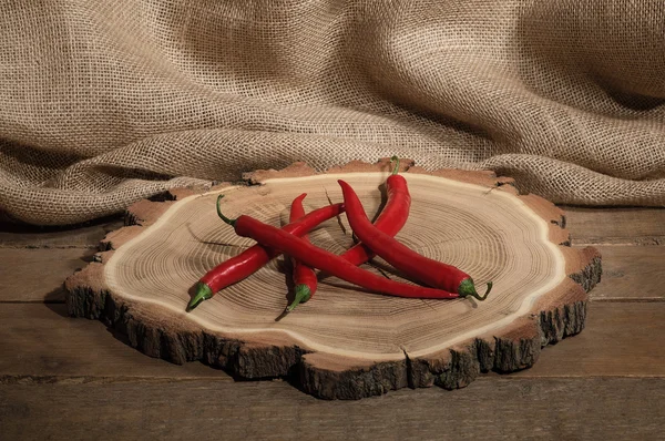 Red hot chili peppers on wooden bagging backround on round plate