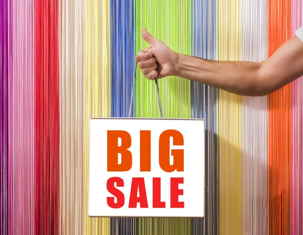 Detail of human hands, to hold,  shop, with a white bag, isolated on background colored blinds.   big sale sign