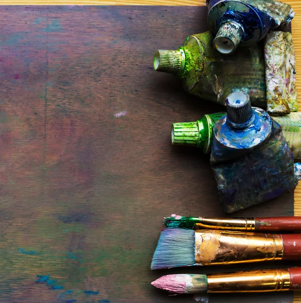 Artist's workshop. Easel with brushes and tubes of paint