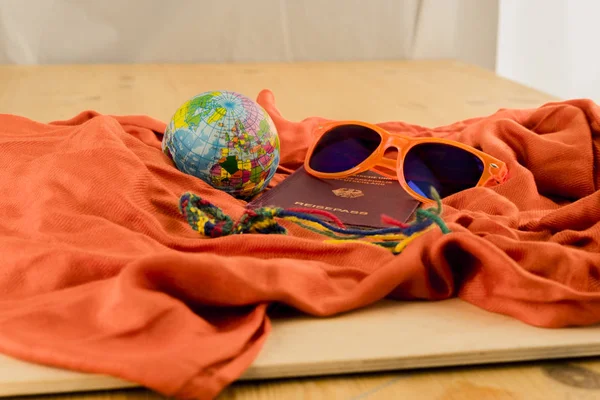 Passport, Globe and Sunglasses on Orange Blanket