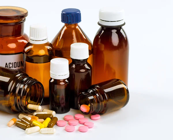 Various cold prescription bottles and a syringe isolated on a wh