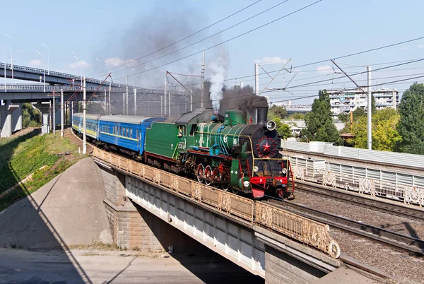 Retro train with steam locomotive in the city. Kiev, Ukraine. Kyiv, Ukraine