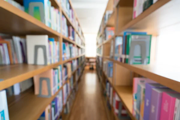 Blurred background of public library, bookshelf with books, diminishing perspective, education concept