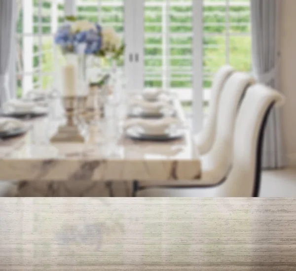 Granite table top and blur of dining table and comfortable chairs in vintage style with elegant table setting