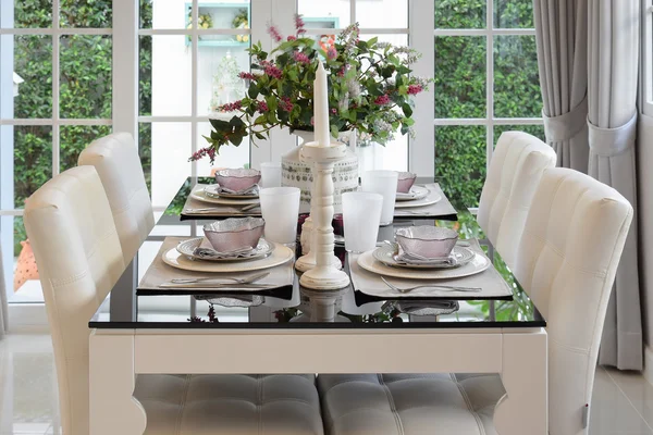 Dining table and comfortable chairs in vintage style with elegant table setting