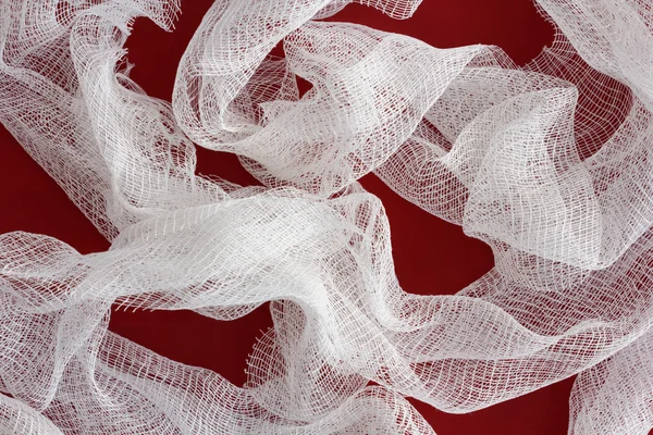 Medical white bandage on a dark red background