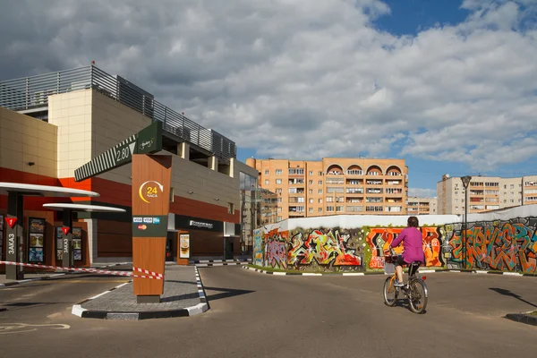 Daytime street view of the city with a woman riding bike