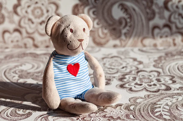 Childrens soft toy teddy bear sits on the couch in the nursery