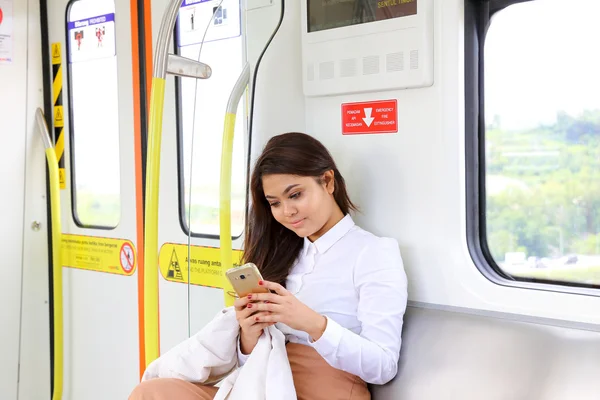 Asian young woman in train transport sit use smartphone