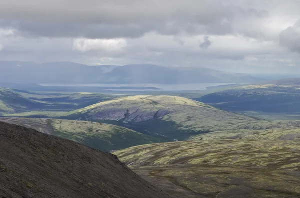 Mountain valley with mosses and rocks covered with lichens. Cloudy sky before storm.  Khibiny mountains above the Arctic circle, Kola peninsula, Russia