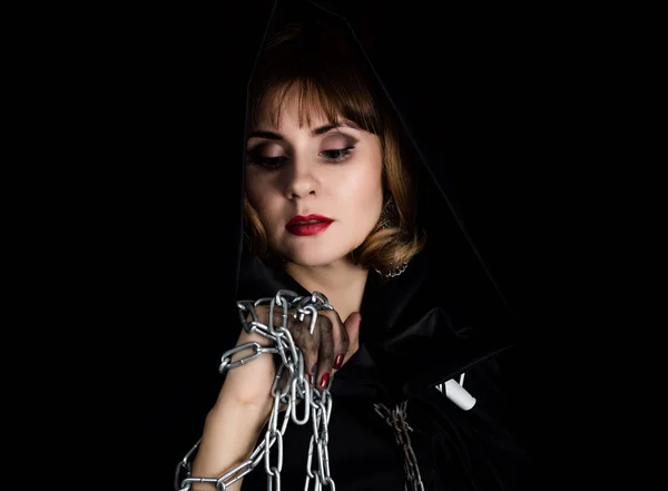 Mysterious young woman holding rope and chain. on a dark background